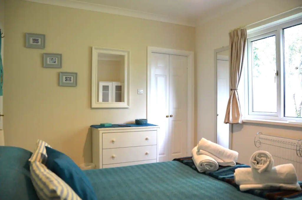 Bedroom 1 showing doors to ensuite bathroom in The Little Red House Mumbles Gower holiday cottage.