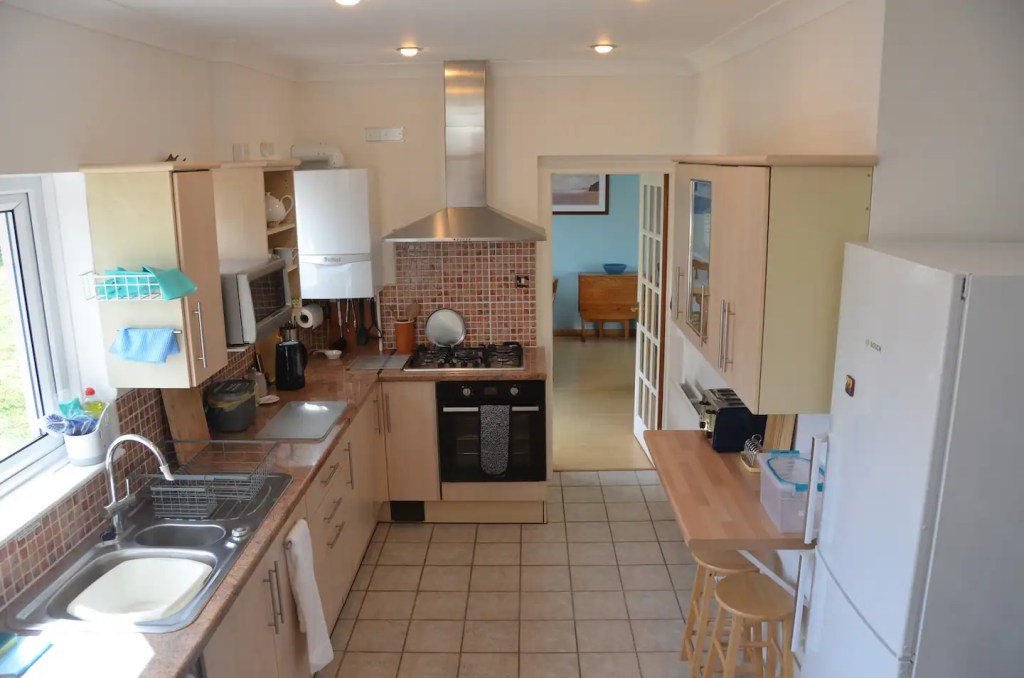 Well equipped kitchen at The Little Red House Mumbles holiday cottage with dishwasher, gas hob, fan oven, microwave, fridge/freezer.