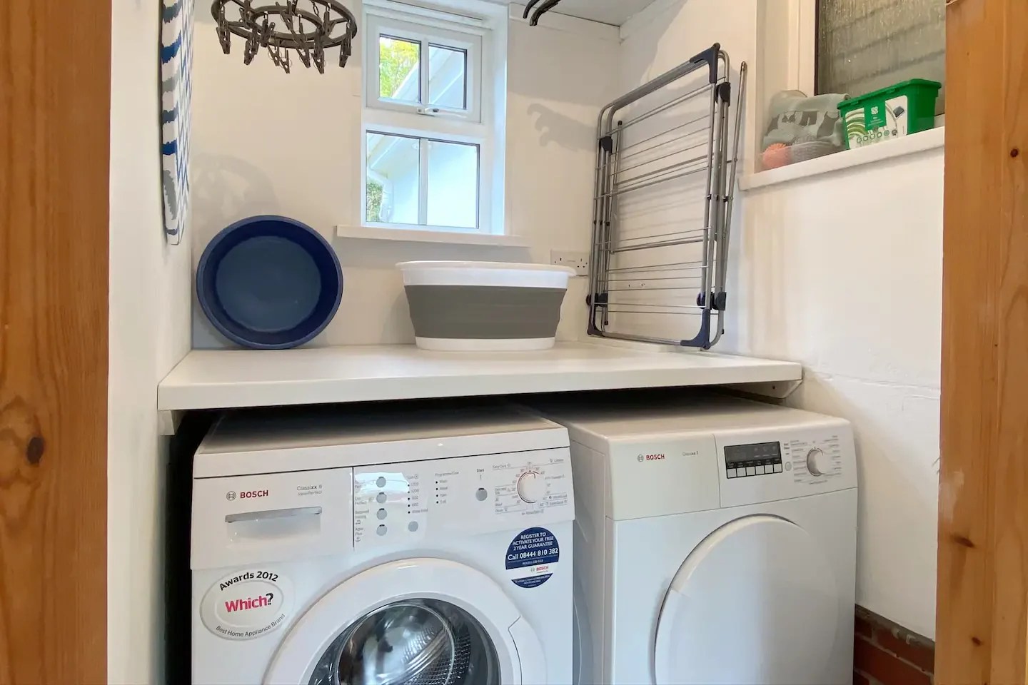 Washing machine, tumble dryer, iron and ironing board at The Little Red House Mumbles holiday cottage, Gower.